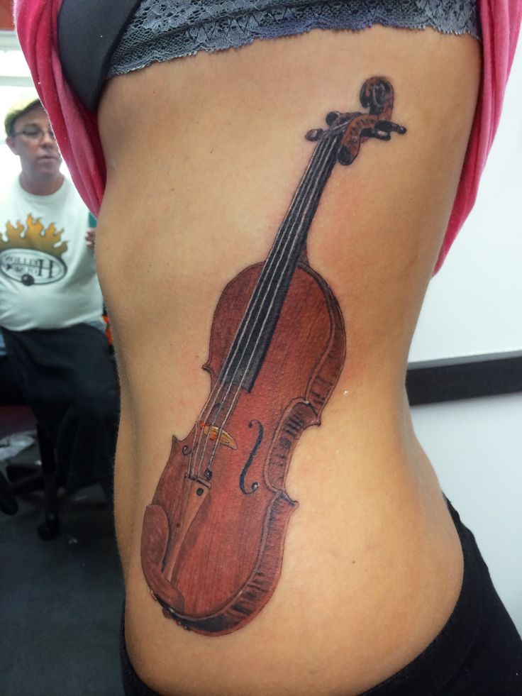 a woman with a violin tattoo on her stomach