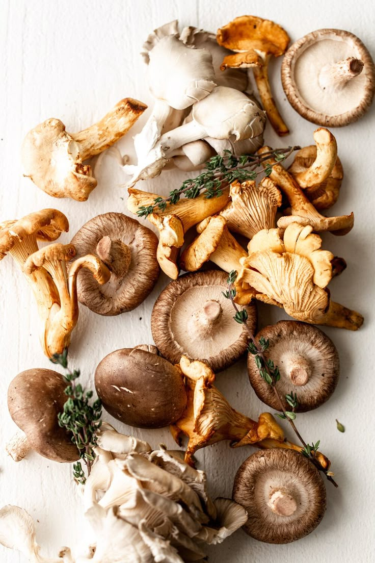 mushrooms and herbs on a white surface