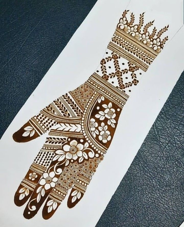 an intricately designed hand is shown on a piece of white paper with gold foil