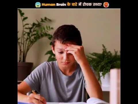 a young man sitting at a table with a book and pen in front of him