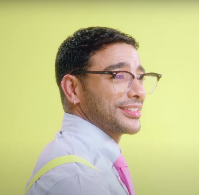 a man with glasses and a pink tie is looking at the camera while he smiles