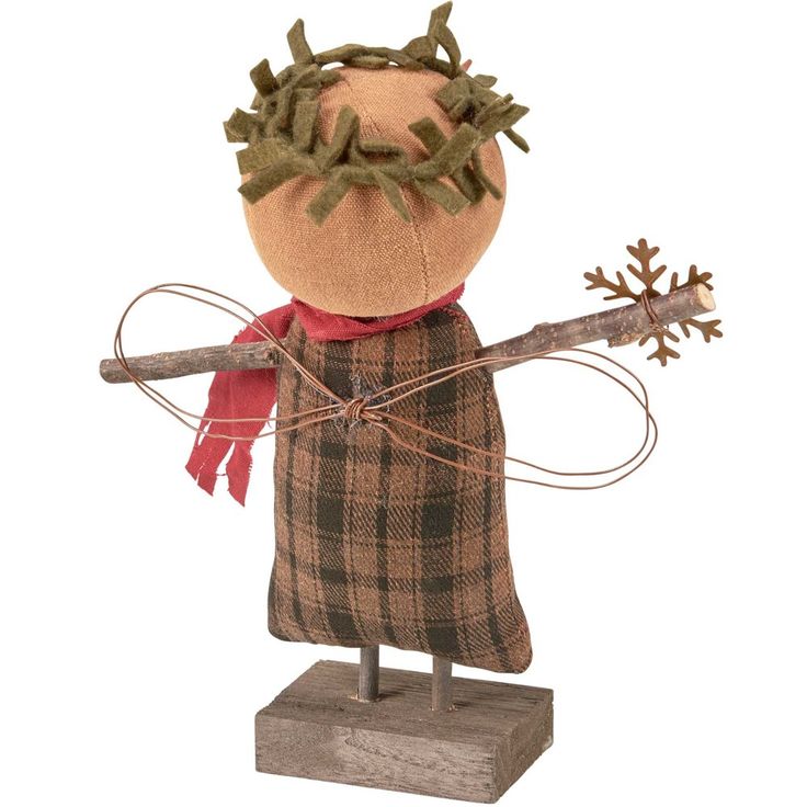 a wooden doll with a red scarf on it's head, holding a stick