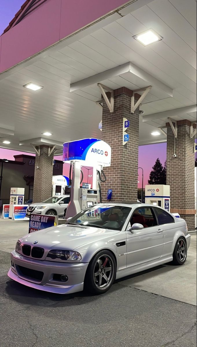 a white car parked in front of a gas station