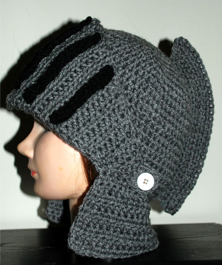 a crocheted hat with buttons on the brim is sitting on a mannequin head