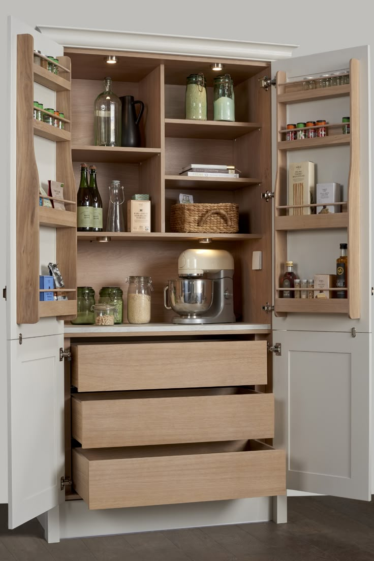 an open cabinet with lots of items in the cupboards and on the shelf is a mixer