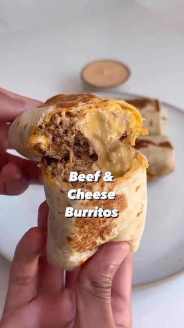 someone is holding up a burrito with cheese on it