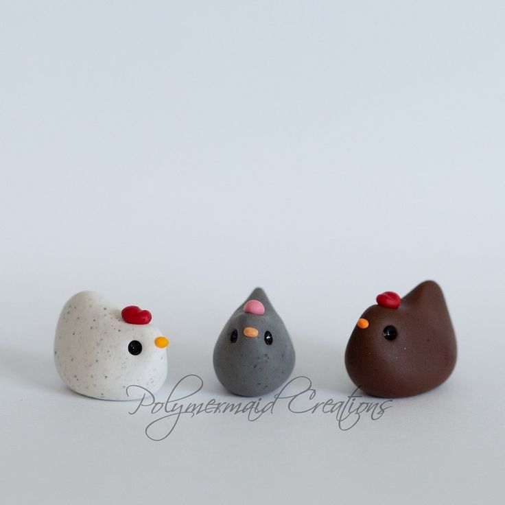 three small rocks with different designs and colors in the shape of chickens, roosters and hens