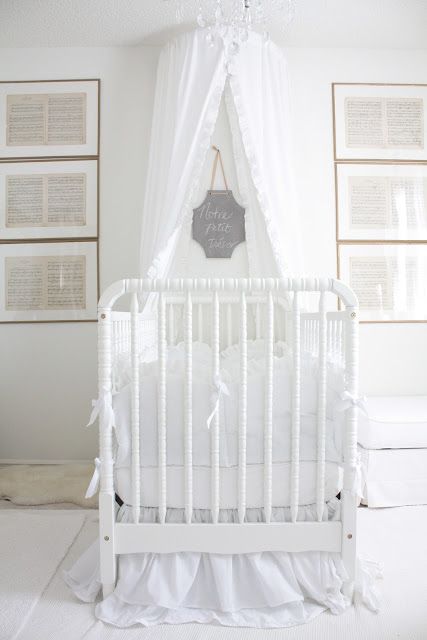 the baby crib is white with ruffled curtains and a sign that says save