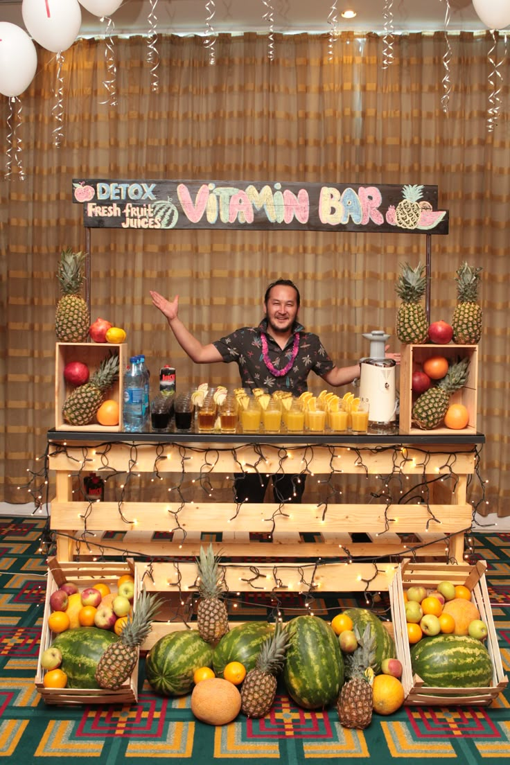 a man standing in front of a display of fruits and juices on a table