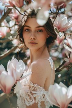 a woman standing under a tree with pink flowers