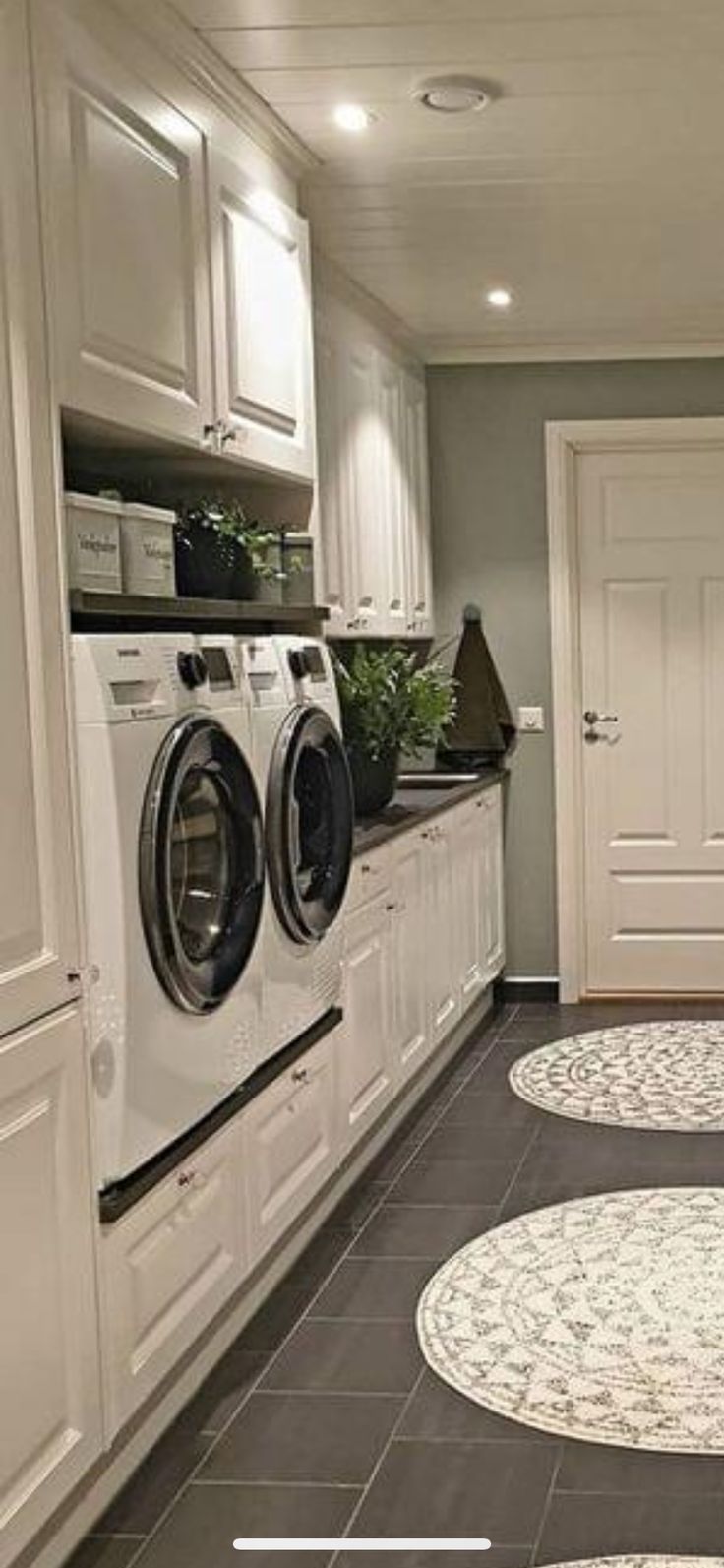 a laundry room with washer, dryer and cabinets on the floor next to each other