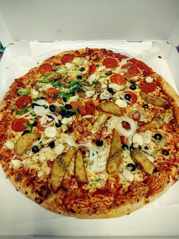 a pizza in a white box with toppings on the top and bottom half is shown