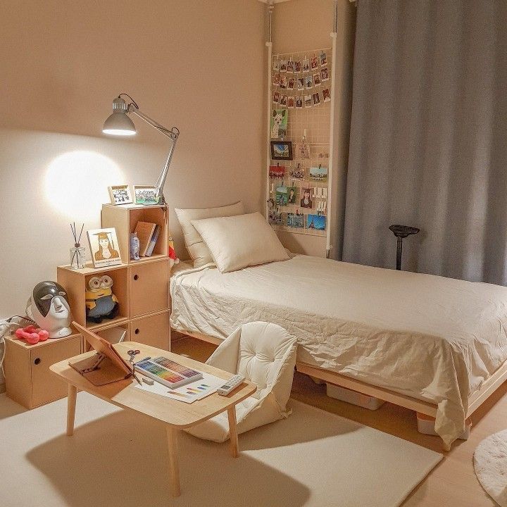 a bedroom with a bed, desk and chair next to a wall mounted book shelf