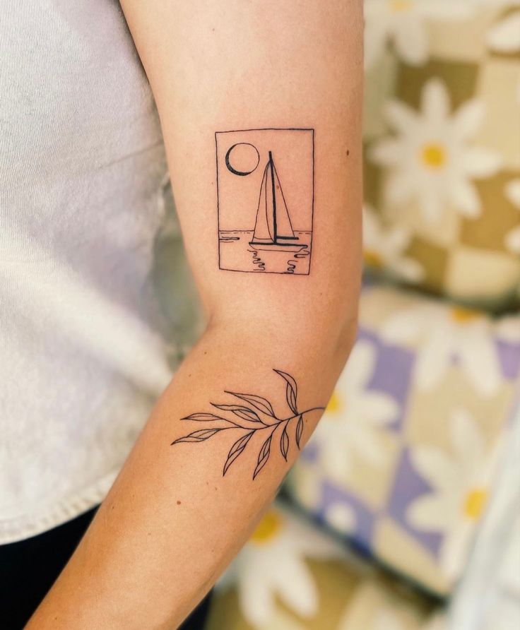 a woman's arm with a small sailboat tattoo on the left inner arm