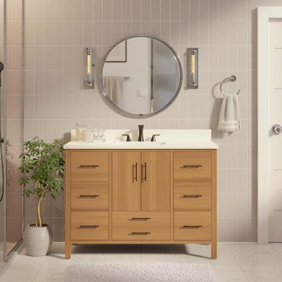 a bathroom with a sink, mirror and shower stall in it's center area