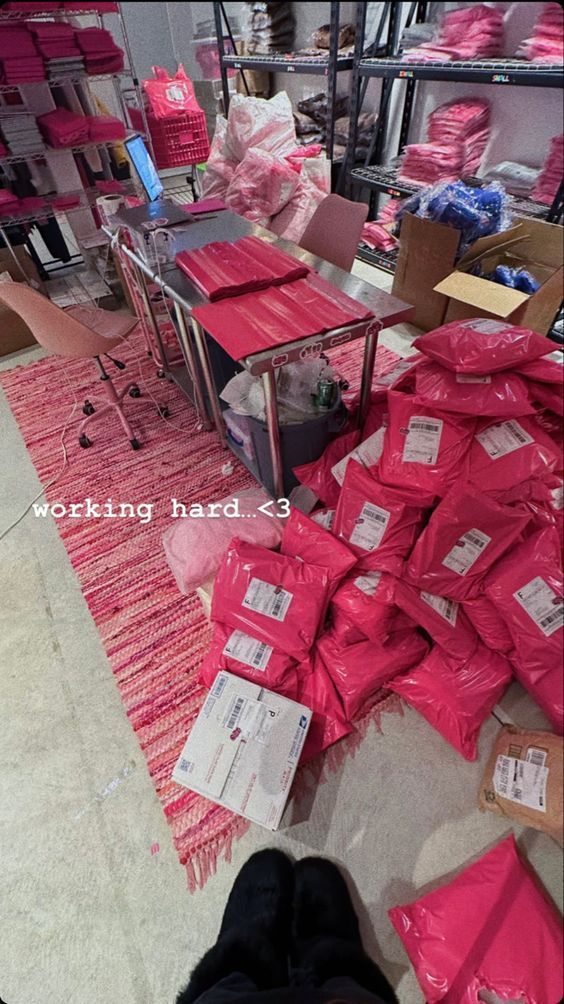 a pile of pink bags sitting on top of a floor next to a red rug