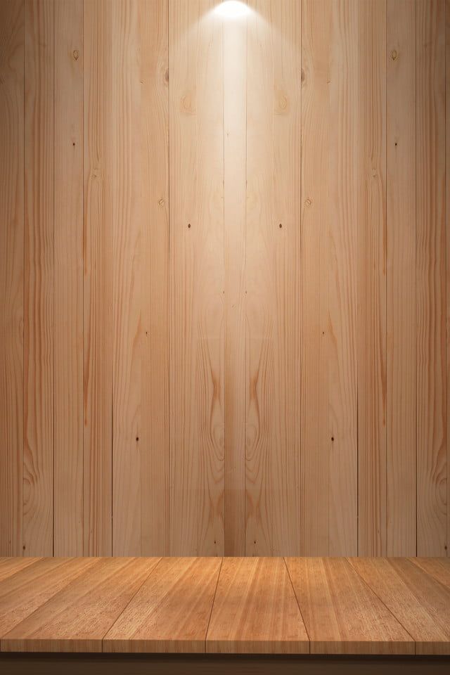 an empty room with wooden floor and lighting on the wall behind it, in front of a wood paneled wall