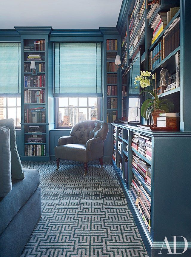 a living room filled with furniture and bookshelves covered in lots of bookcases