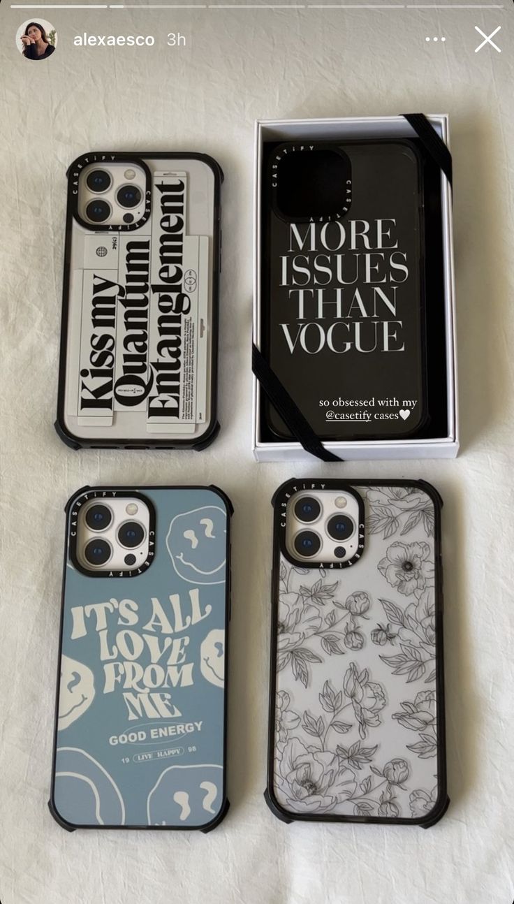 four cell phones sitting next to each other on top of a white sheet covered table