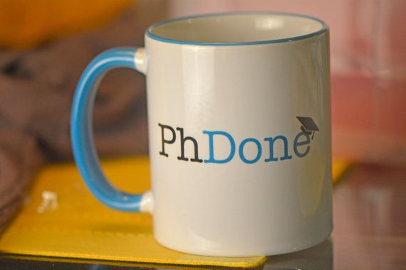 a blue and white coffee mug with the word ph donee on it sitting on a table