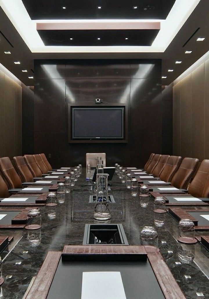 an empty conference room set up for a meeting with leather chairs and black marble table