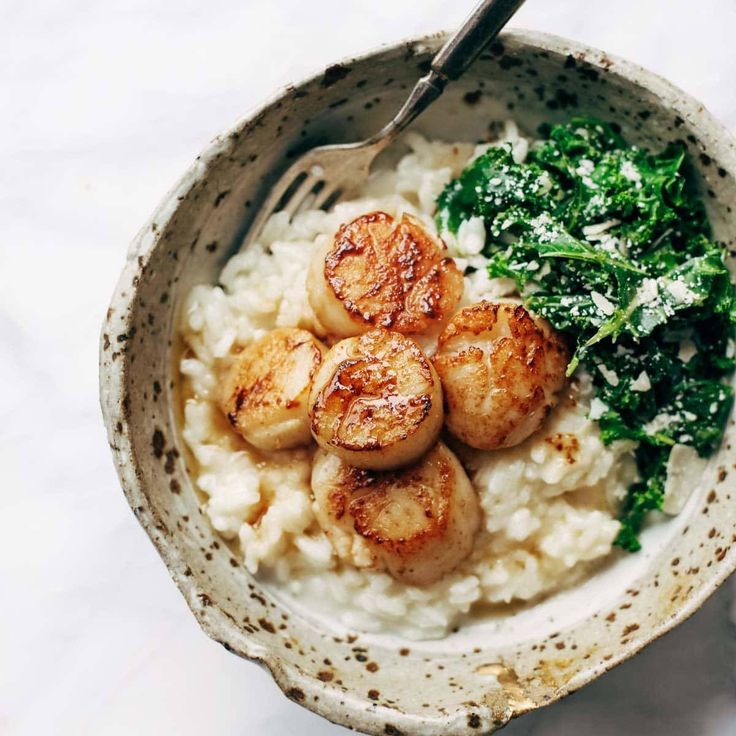 a bowl filled with rice and seared scallops