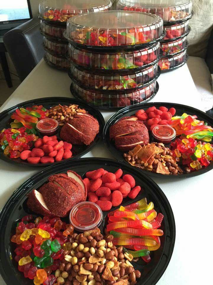 four plates filled with food on top of a white table next to stacks of plastic containers