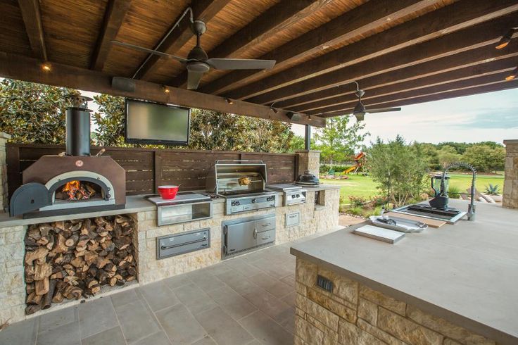 an outdoor kitchen with wood burning oven and grill