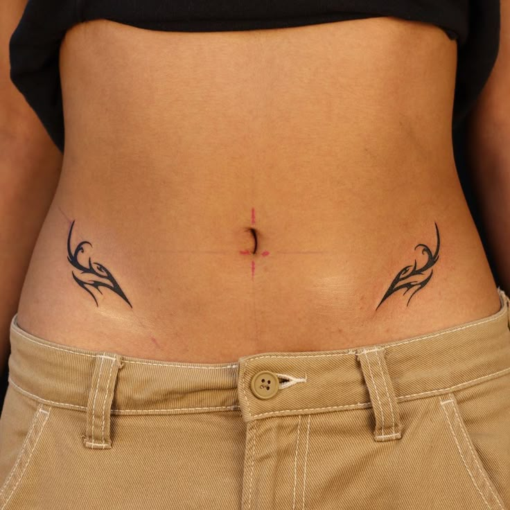 a woman's stomach with tattoos on her lower body and the bottom part of her abdomen