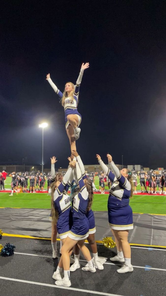 the cheerleaders are doing tricks for the crowd