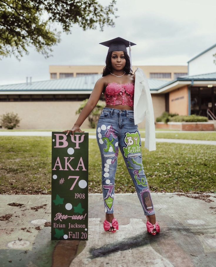 a woman in high school cap and jeans holding a sign