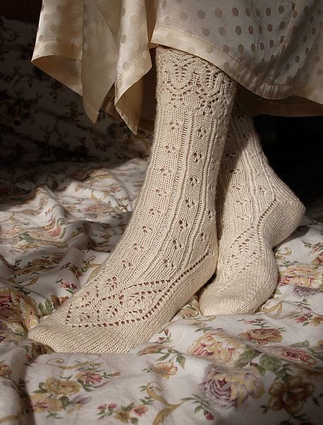 there is a woman's feet wearing socks and stockings on the bed with floral bedspread