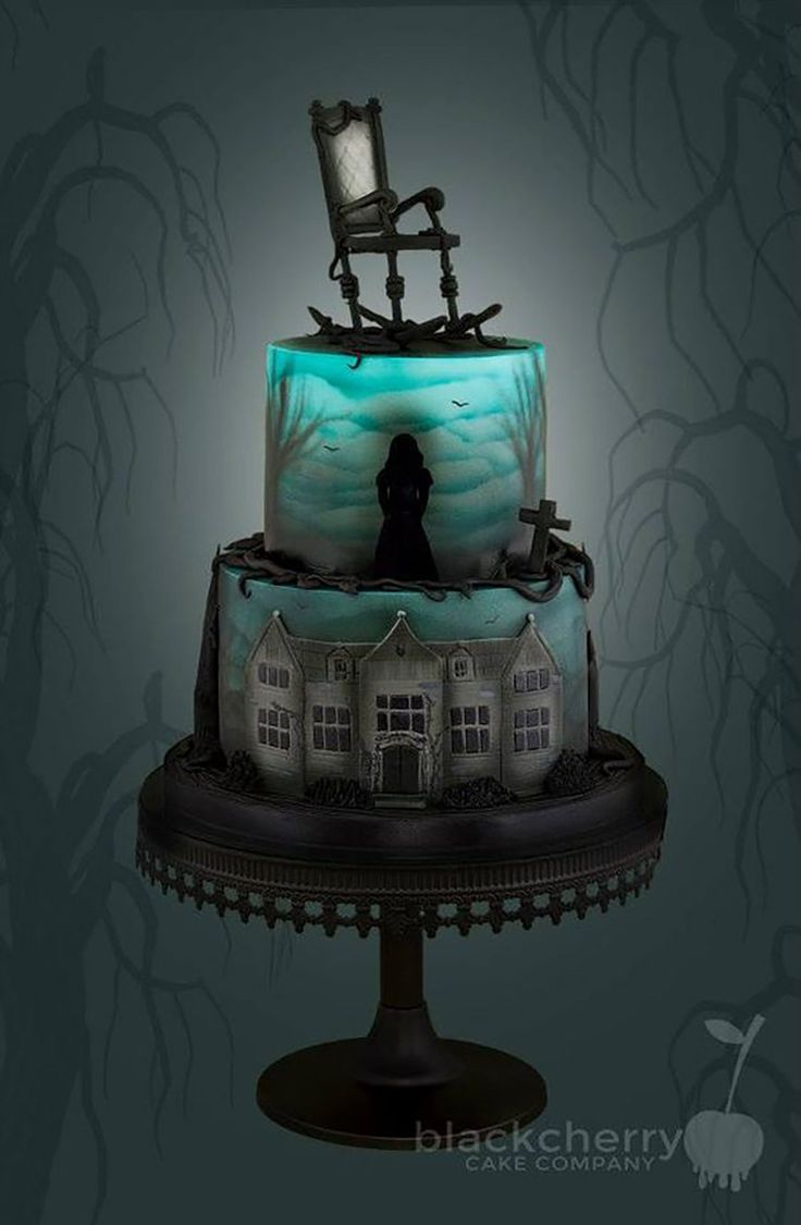 a three tiered cake with an image of a house on top and a person standing in front of it