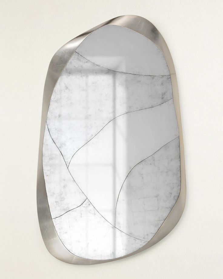 a mirror that is on the wall with some kind of design in it's frame