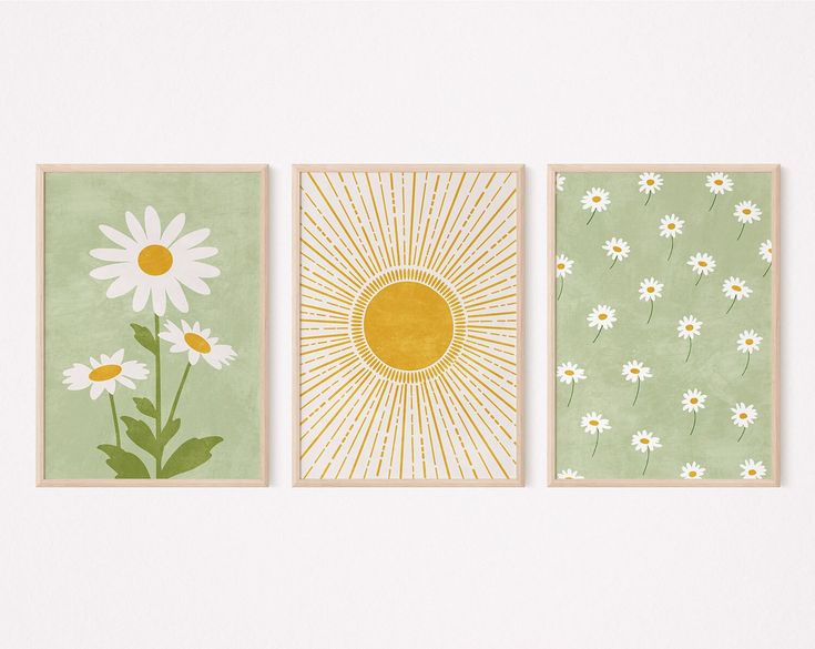 three flower paintings are hanging on the wall next to each other, one has a sun and two have daisies