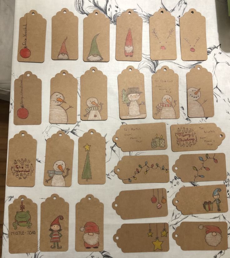 several tags with christmas characters on them sitting on a table