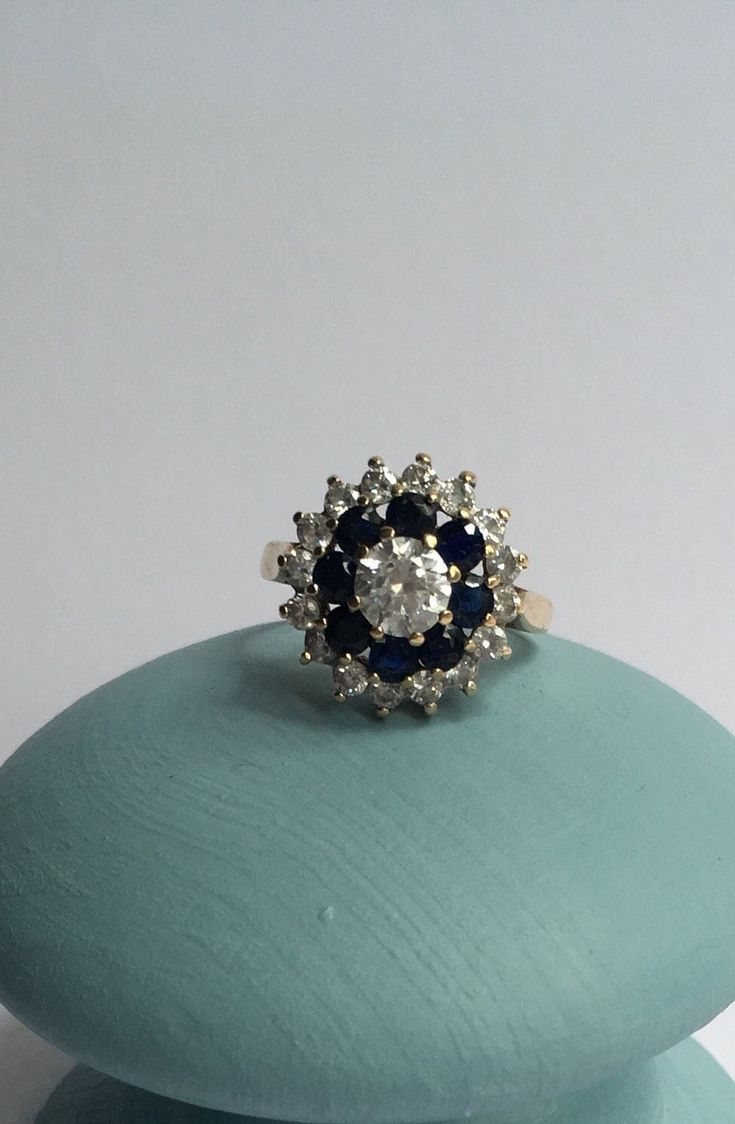 a blue and white ring sitting on top of a rock