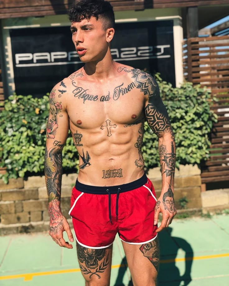 a shirtless man with tattoos on his chest and arms