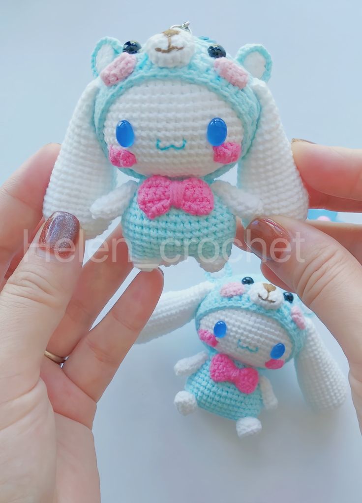 two small crocheted stuffed animals are being held by someone's hands with their fingers