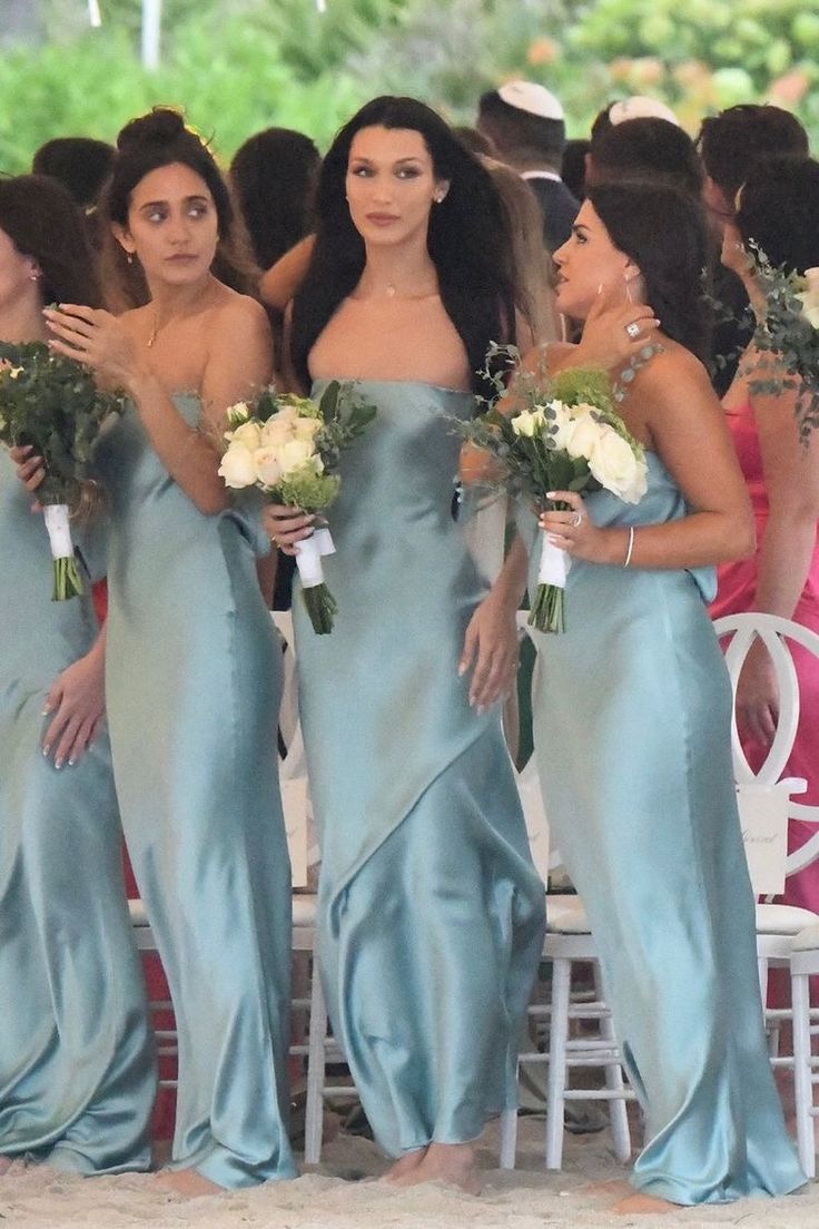 a group of women standing next to each other holding bouquets in front of them