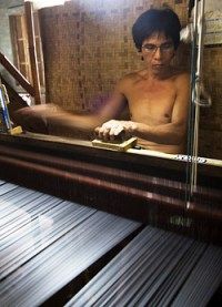 a shirtless man sitting in front of a mirror