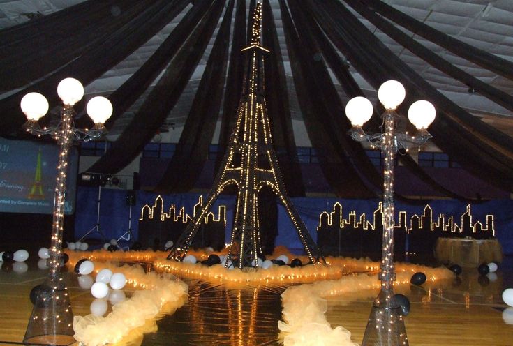 a large tent with lights and decorations on the floor, in front of a projection screen