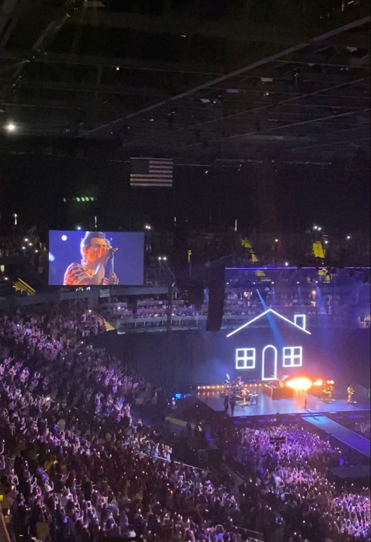 a large group of people in an arena watching a concert