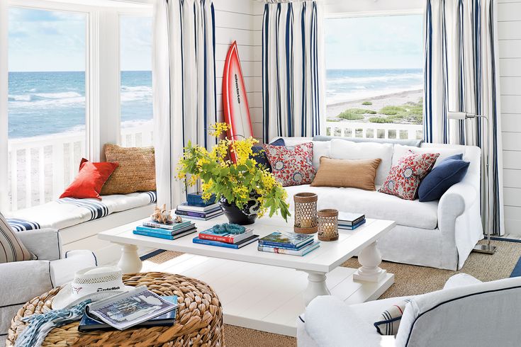 a living room filled with white furniture and lots of window sill covered in colorful pillows