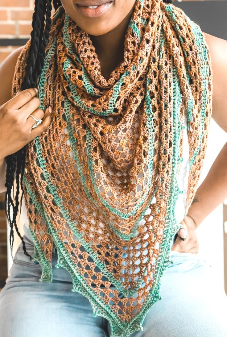 a woman wearing a crocheted scarf with braids