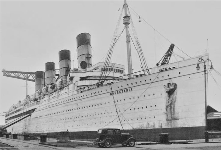 an old black and white photo of a large ship in dry dock with cars parked next to it