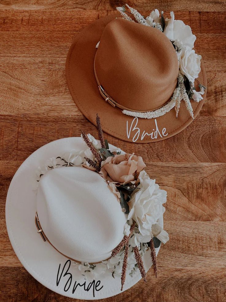 two hats with name written on them sitting on a wooden floor next to each other