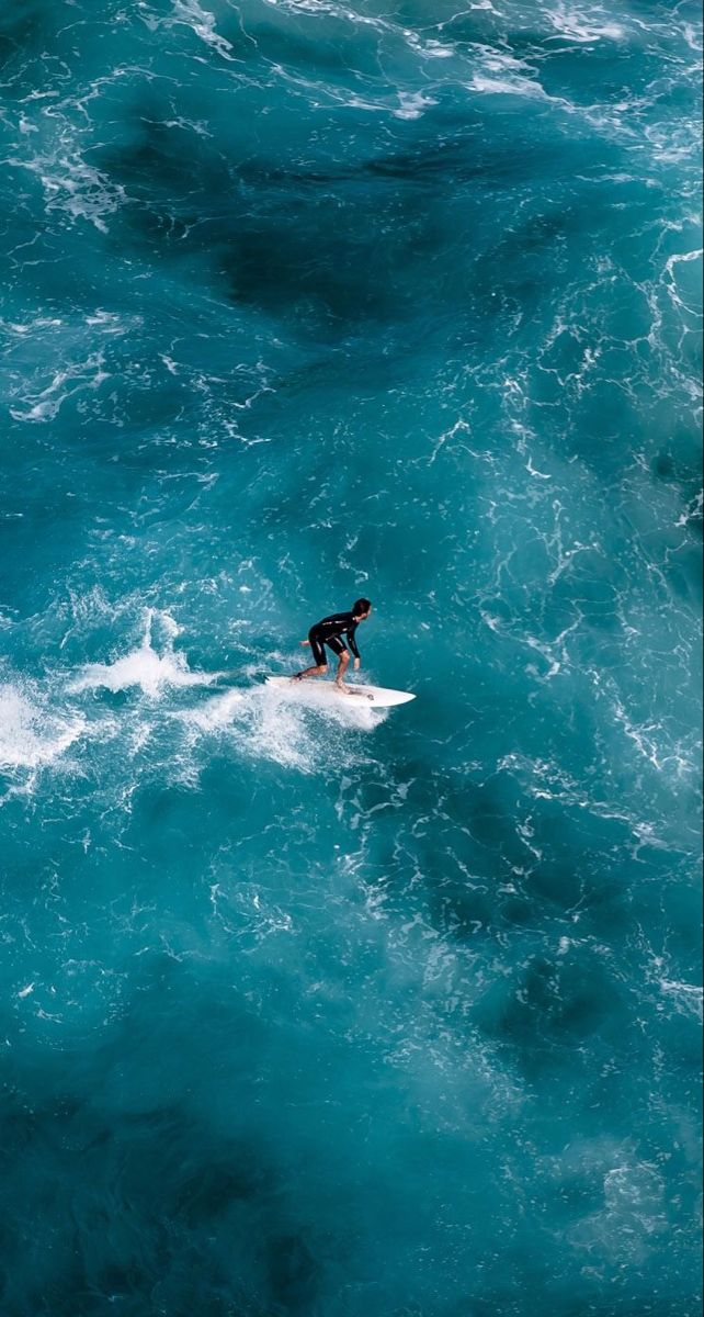 a person on a surfboard in the middle of some blue ocean water with waves