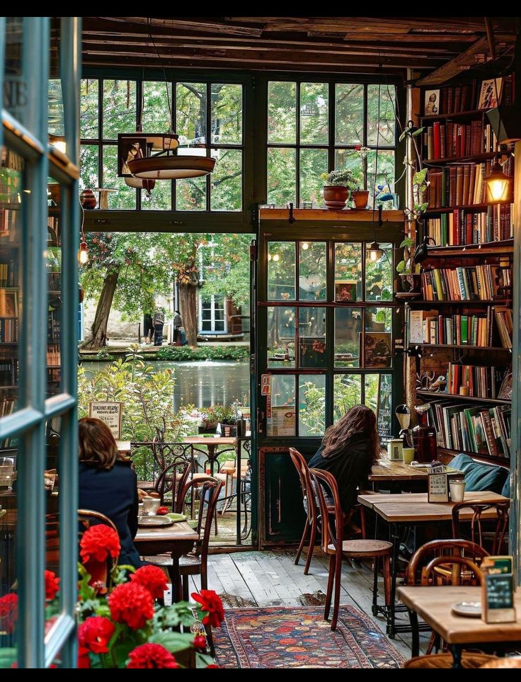 a person sitting at a table in a room filled with books