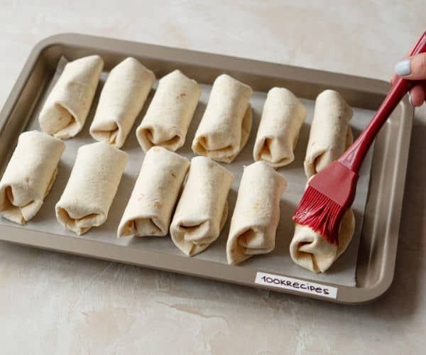 a tray filled with rolled up food and a red brush